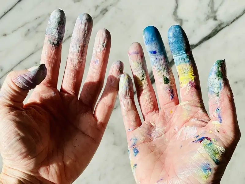 Mains couvertes de peinture de toutes les couleurs